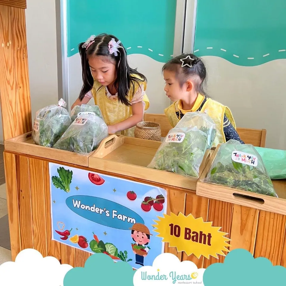 Children arranging bags of leafy vegetables on wooden trays